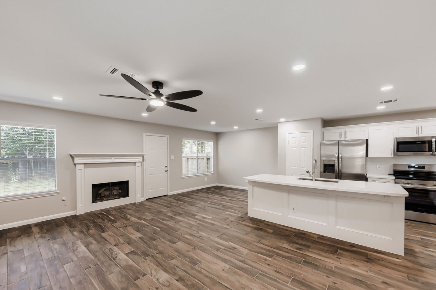 Bright living area with a white mantel fireplace at 11 Wineberry Pl, The Woodlands