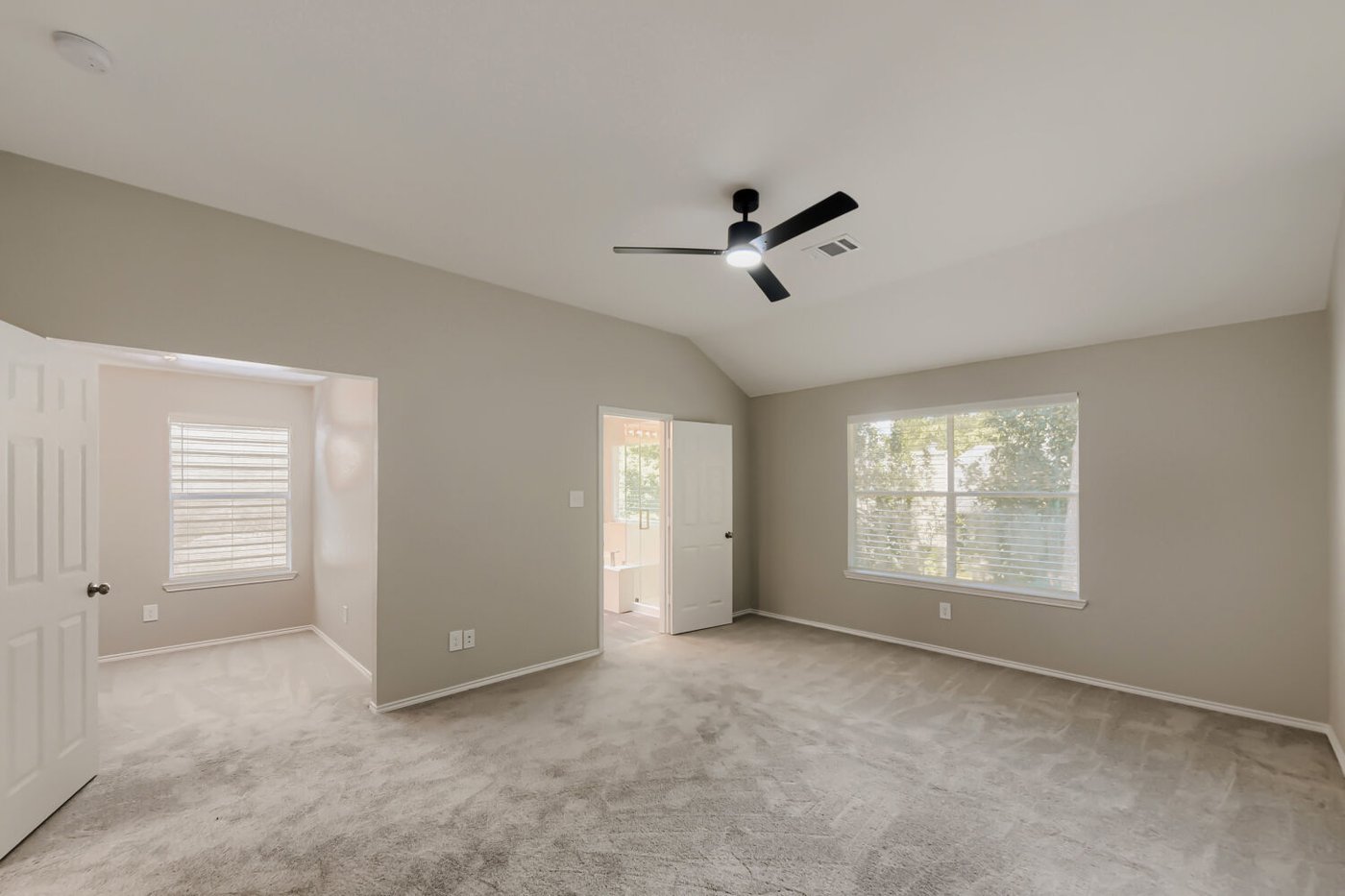 Spacious primary bedroom with natural light at 11 Wineberry Pl, The Woodlands