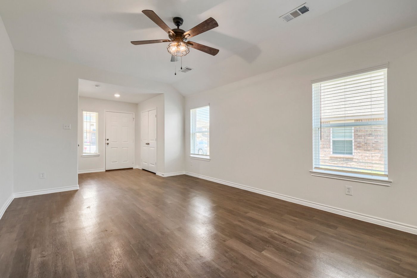 Bright living room with ceiling fan and large windows at 1309 Fantail Ln
