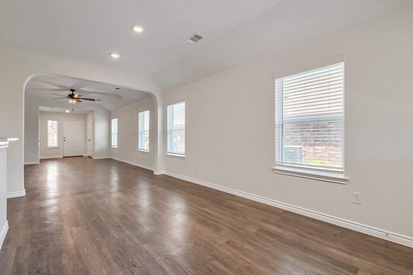 Open living room with laminate wood flooring at 1309 Fantail Ln, Ennis, TX