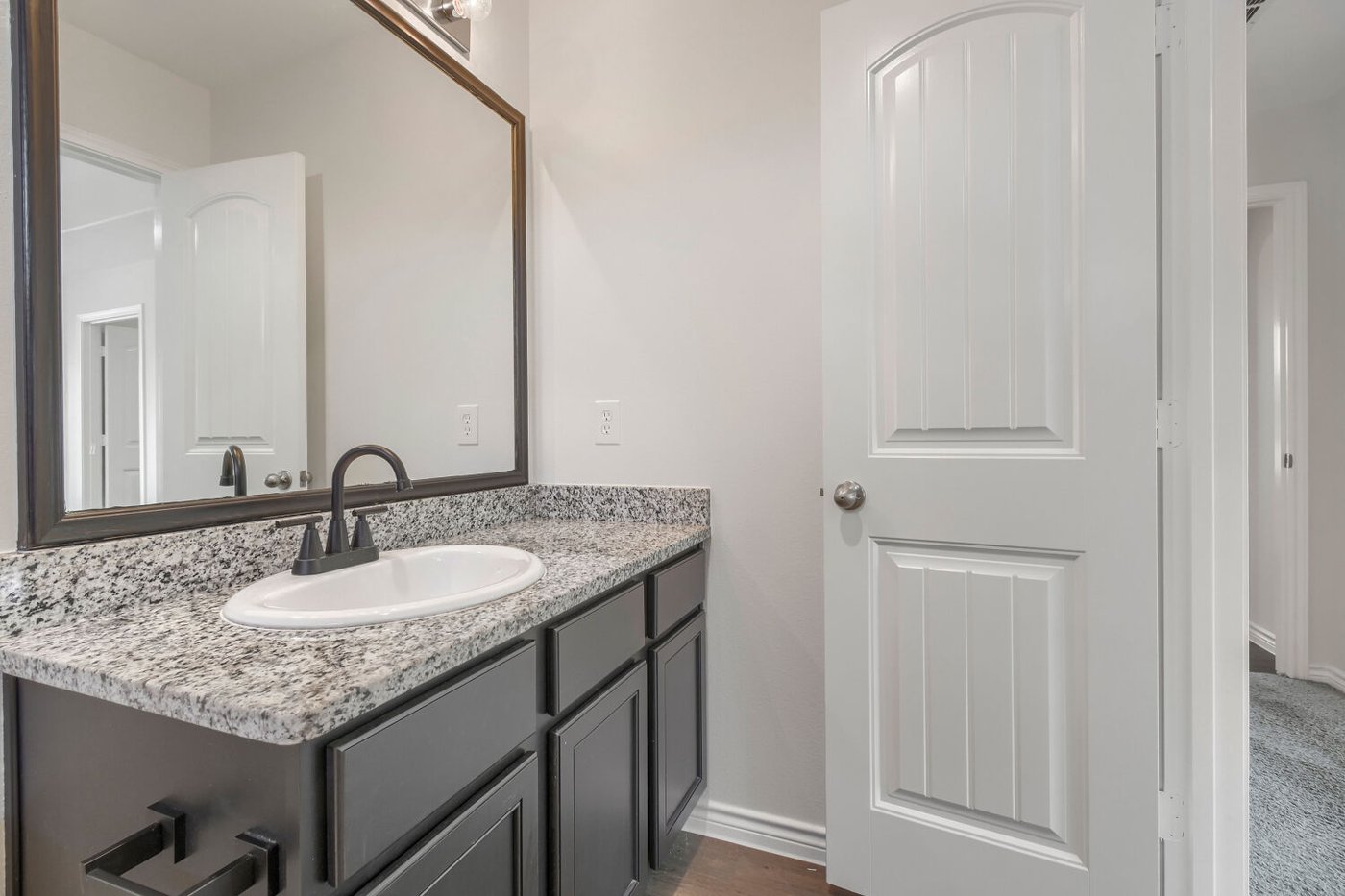 Primary bath vanity with a large mirror at 1309 Fantail Ln, Ennis, TX