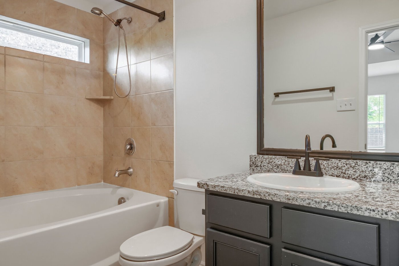 Primary bathroom with granite vanity and a tub shower combination at 1309 Fantail Ln