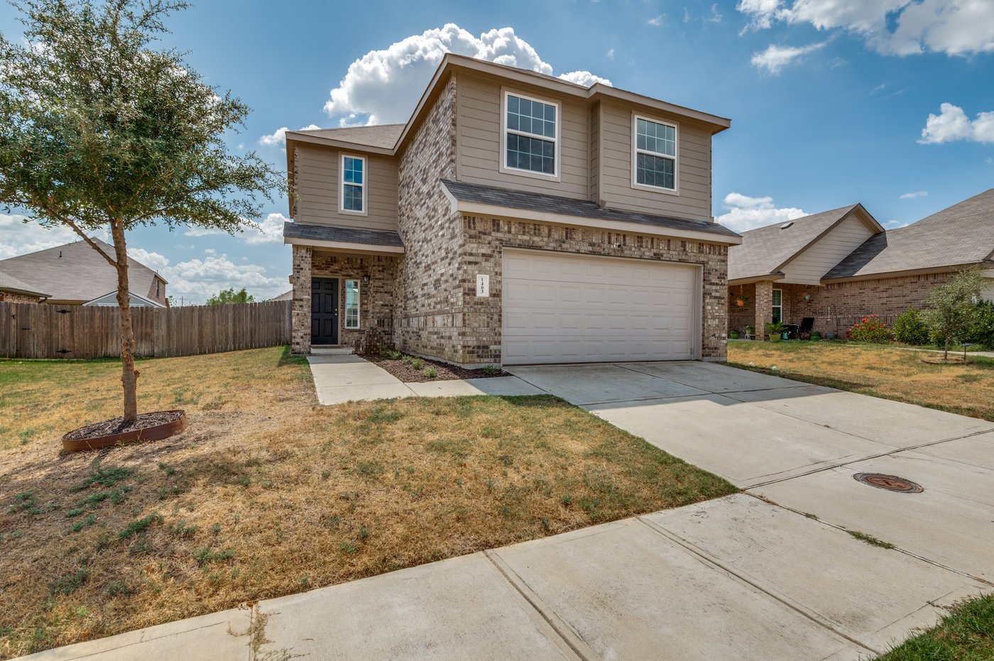 Angled front view of 1403 Kinglet Dr with a two car garage in Ennis, TX