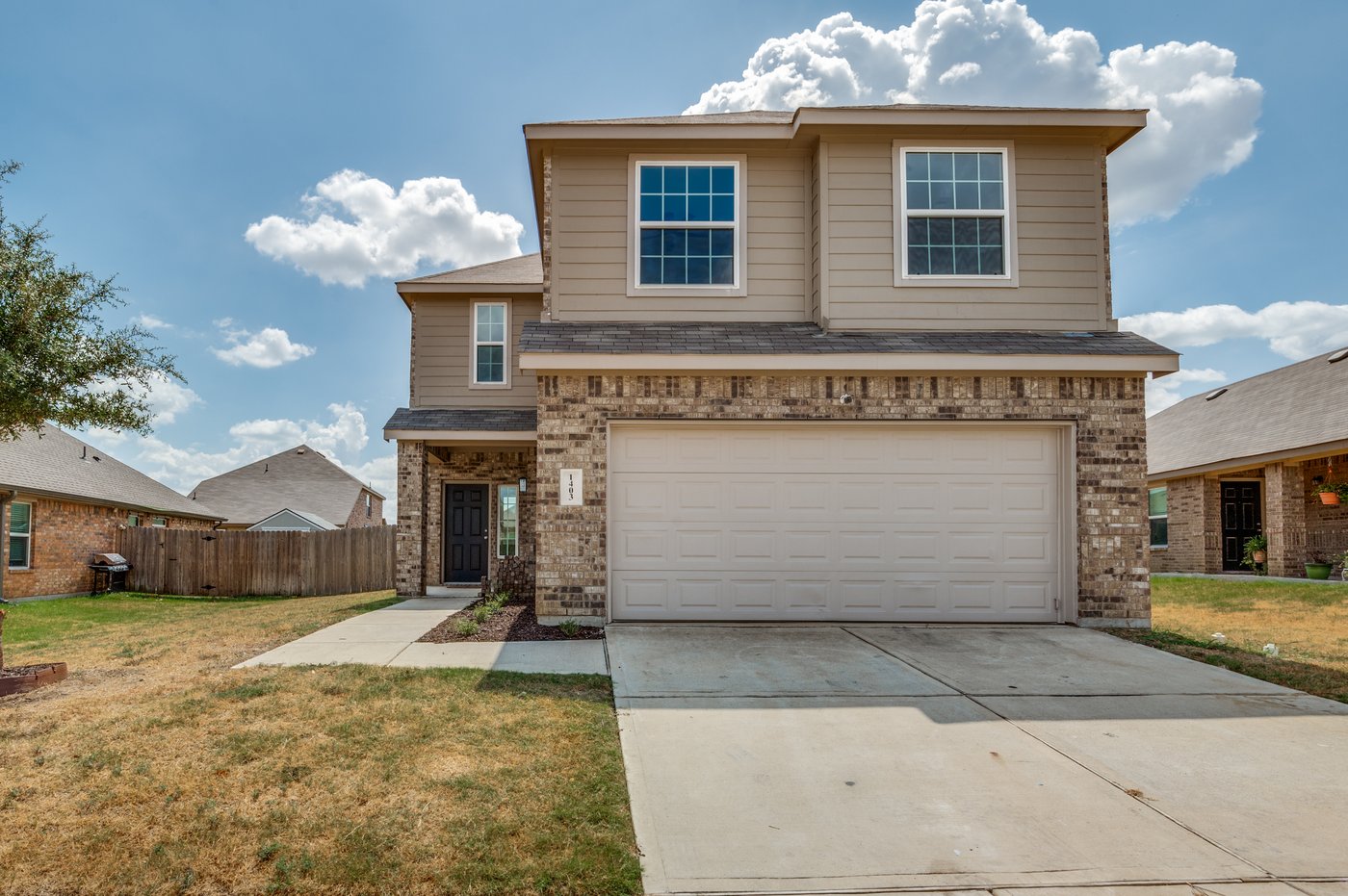 Front exterior of 1403 Kinglet Dr, a two story brick and stone home for sale in Ennis, TX