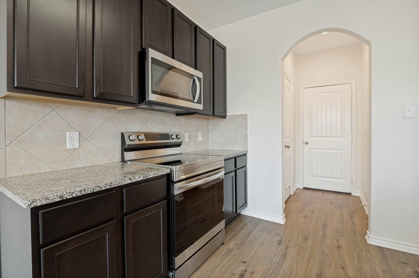 Kitchen with dark cabinetry and stainless steel appliances at 1403 Kinglet Dr, Ennis