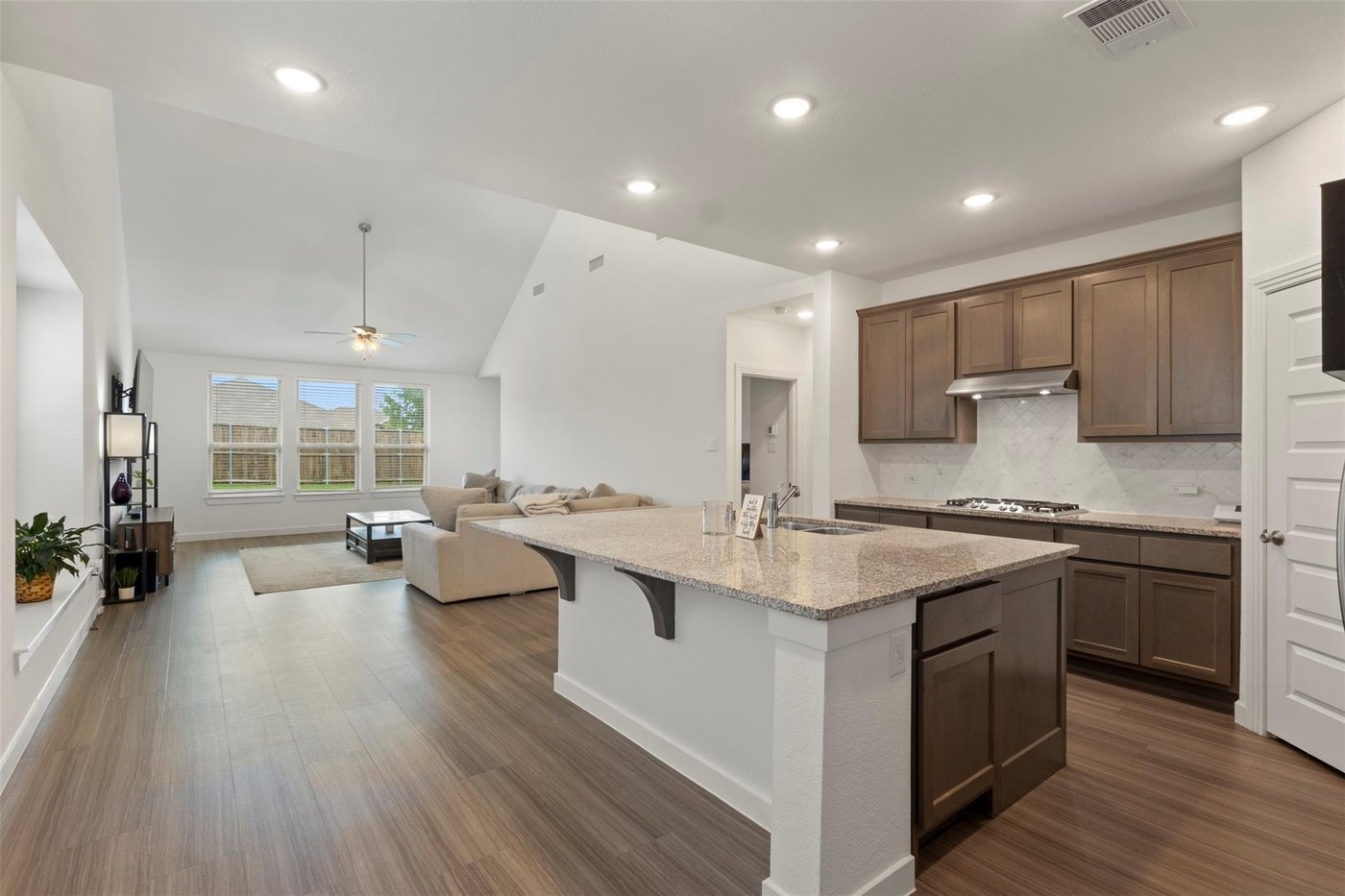 Granite island kitchen open to the living area at 1848 Coronet Ave, Aubrey