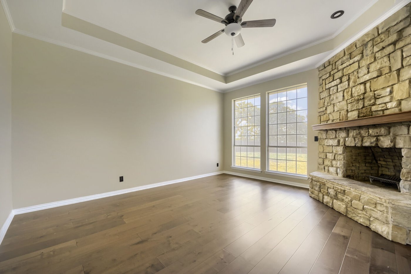 Living room with a stone fireplace and oversized windows at 201 N Garza Rd, Shady Shores, TX
