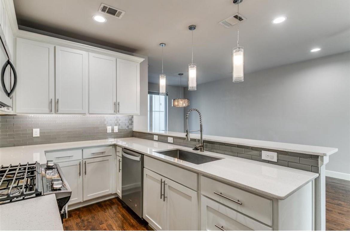 Kitchen with a large peninsula and pendant lighting at 2016 N Fitzhugh Ave #104, Dallas