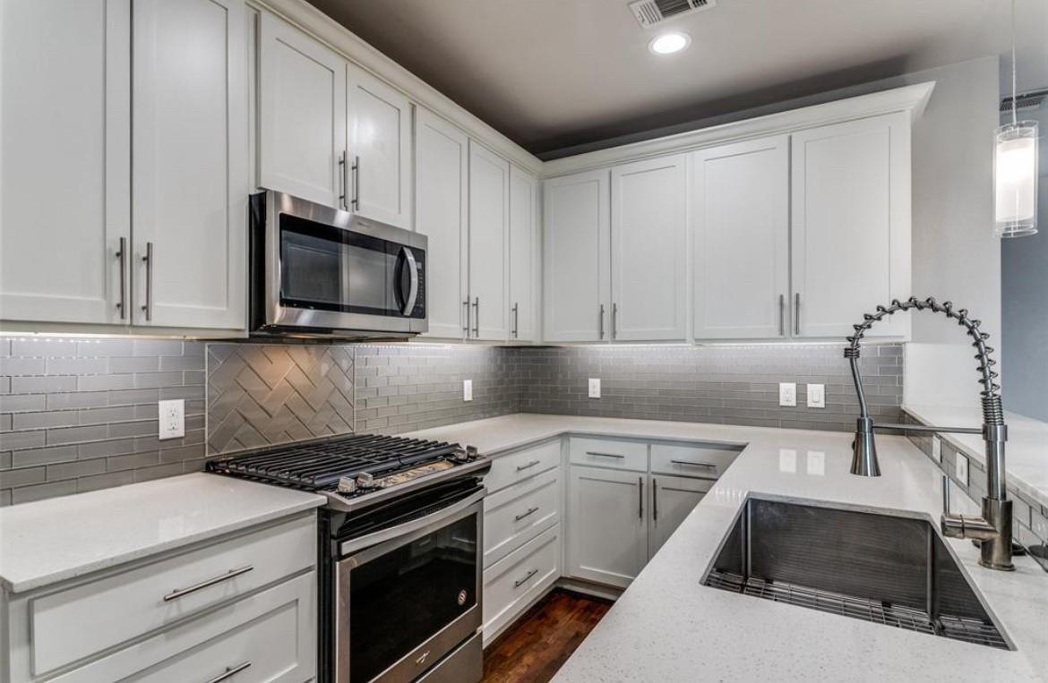 Chef's kitchen with quartz counters, a gas range, and stainless steel appliances at 2016 N Fitzhugh Ave #104, Dallas