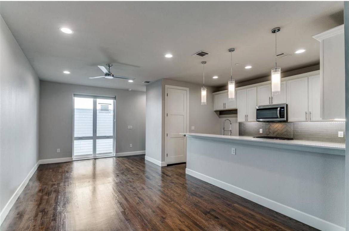 Open living area with hardwood floors overlooking the kitchen at 2016 N Fitzhugh Ave #104, Dallas
