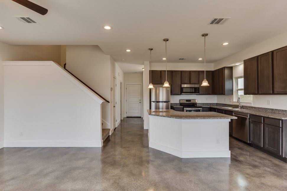 Open kitchen and living area with stained concrete floors at 206 Topaz, New Braunfels