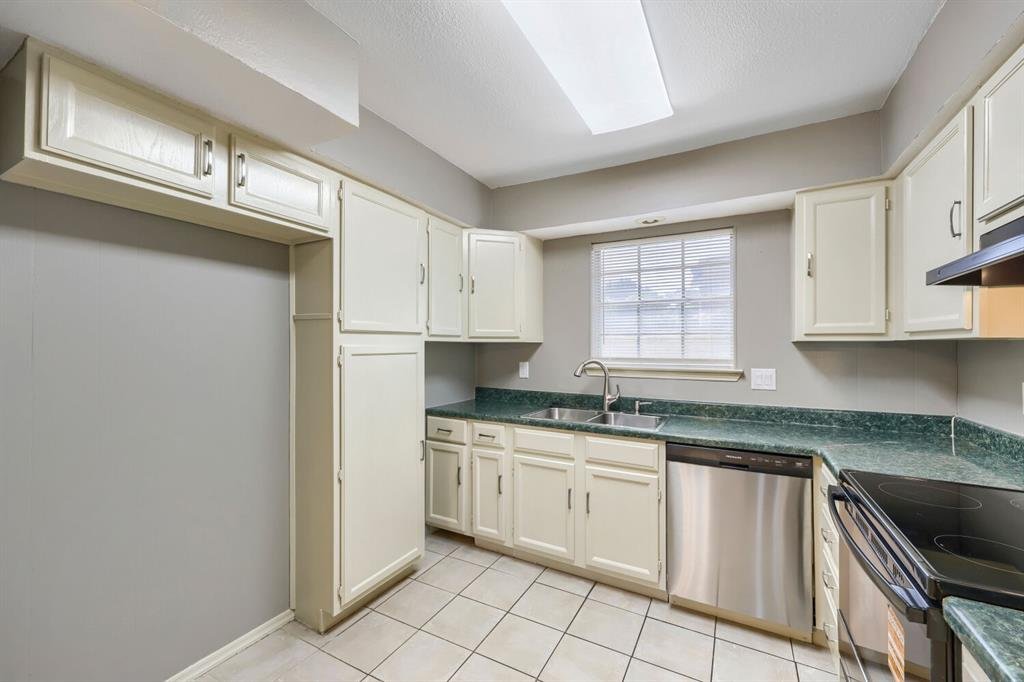 Kitchen with a skylight, pantry, and stainless dishwasher at 22 E Townhouse Ln #31, Grand Prairie