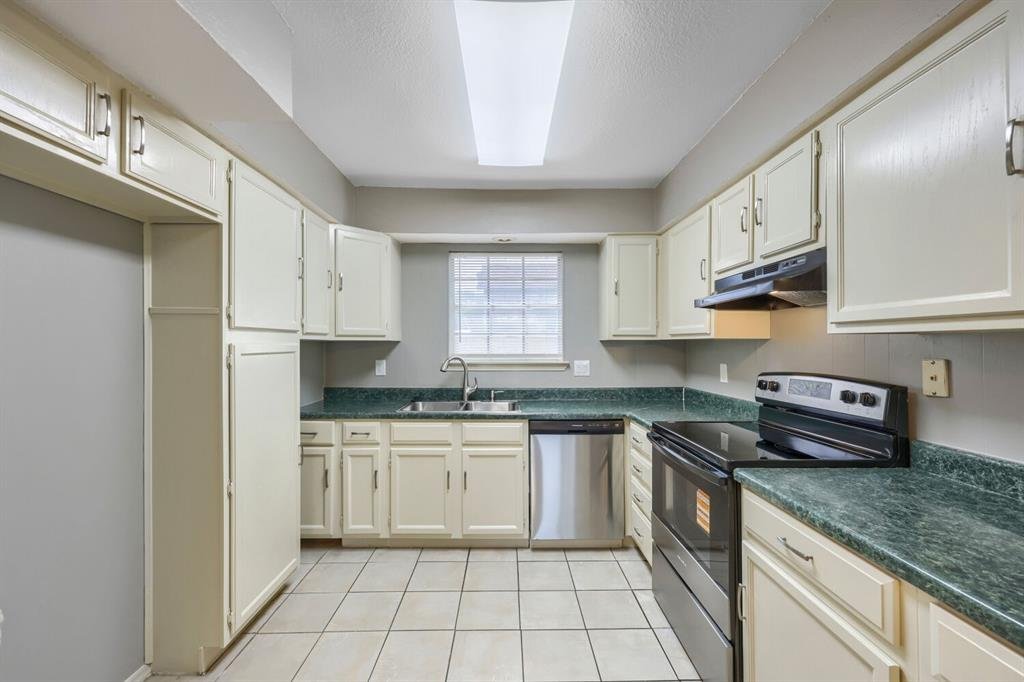 Kitchen with built-in cabinets, dishwasher, and electric range at 22 E Townhouse Ln #31, Grand Prairie