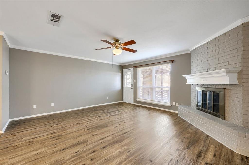Living room with brick fireplace and ceiling fan at 22 E Townhouse Ln #31, Grand Prairie
