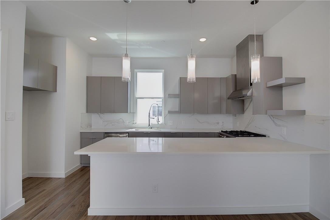 Modern kitchen with quartz island and stainless steel hood at 2310 N Carroll Ave Unit 105