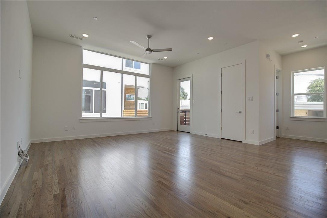 Open living room with Oak wood floors and large windows at 2310 N Carroll Ave Unit 105