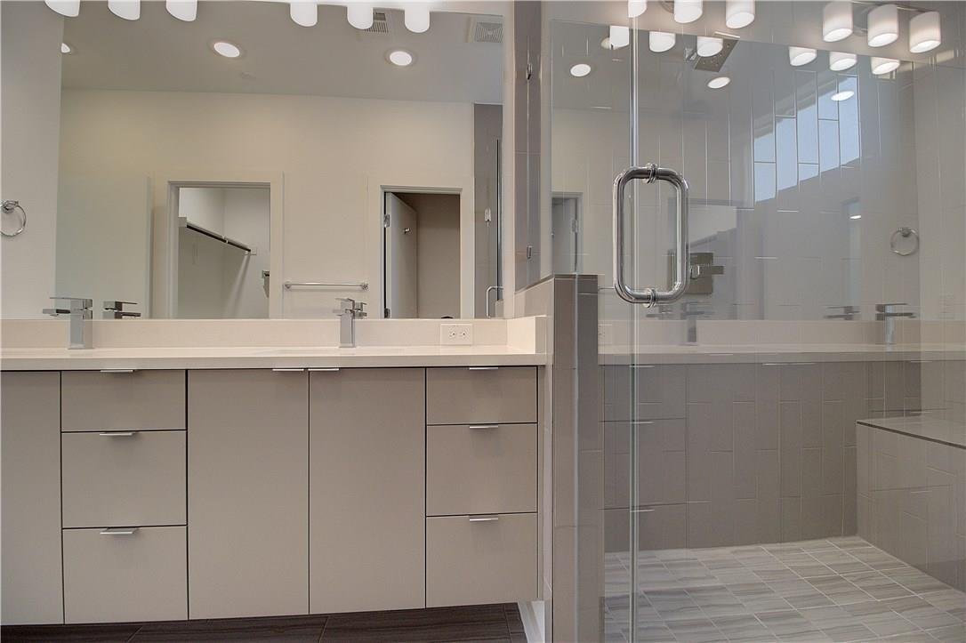 Master bath double vanity with a large mirror at 2310 N Carroll Ave Unit 105, Dallas