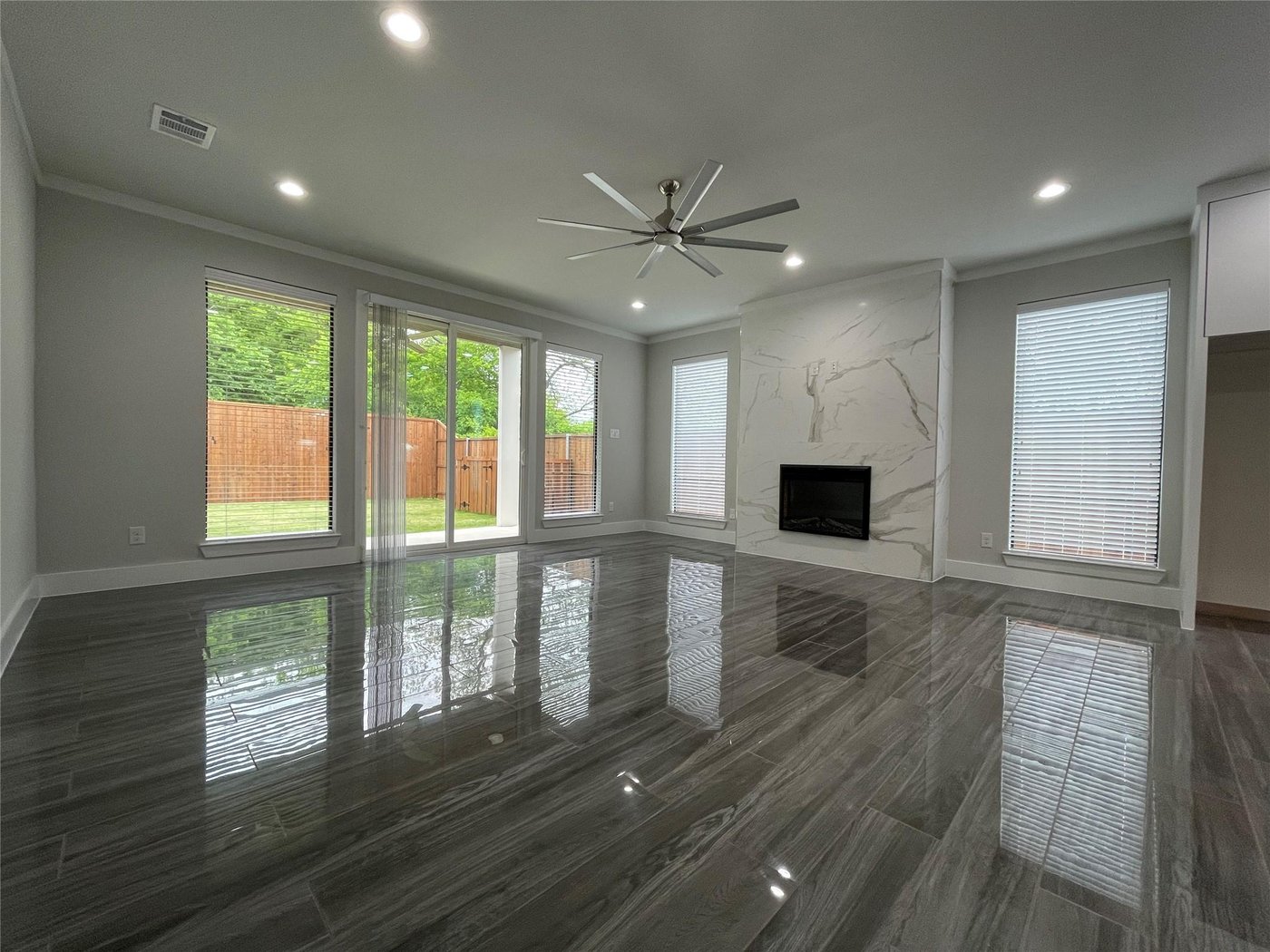 Open concept living room with a fireplace and wood floors at 2417 N Winnetka Ave, Dallas