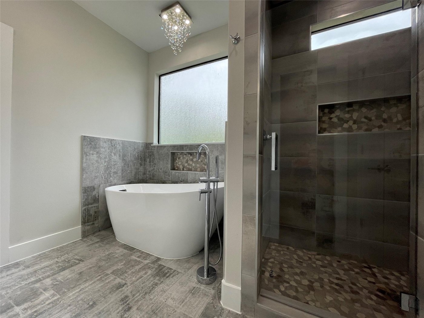 Primary bath with a freestanding tub and tiled shower at 2417 N Winnetka Ave, Dallas