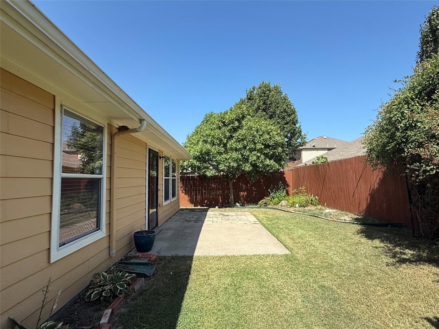 Generously sized backyard with a concrete patio at 3605 Cottonwood Rd, Melissa