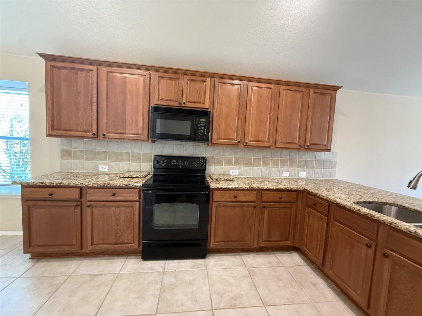Kitchen with black appliances and ample cabinetry at 3605 Cottonwood Rd, Melissa