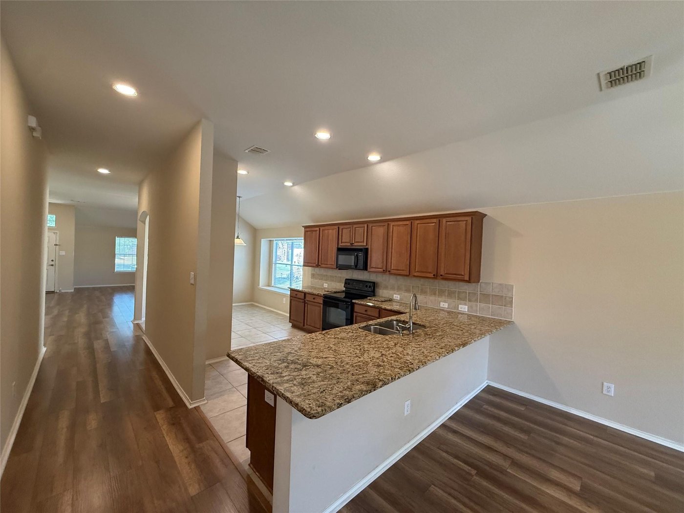 Open kitchen and living area with wood look flooring at 3605 Cottonwood Rd