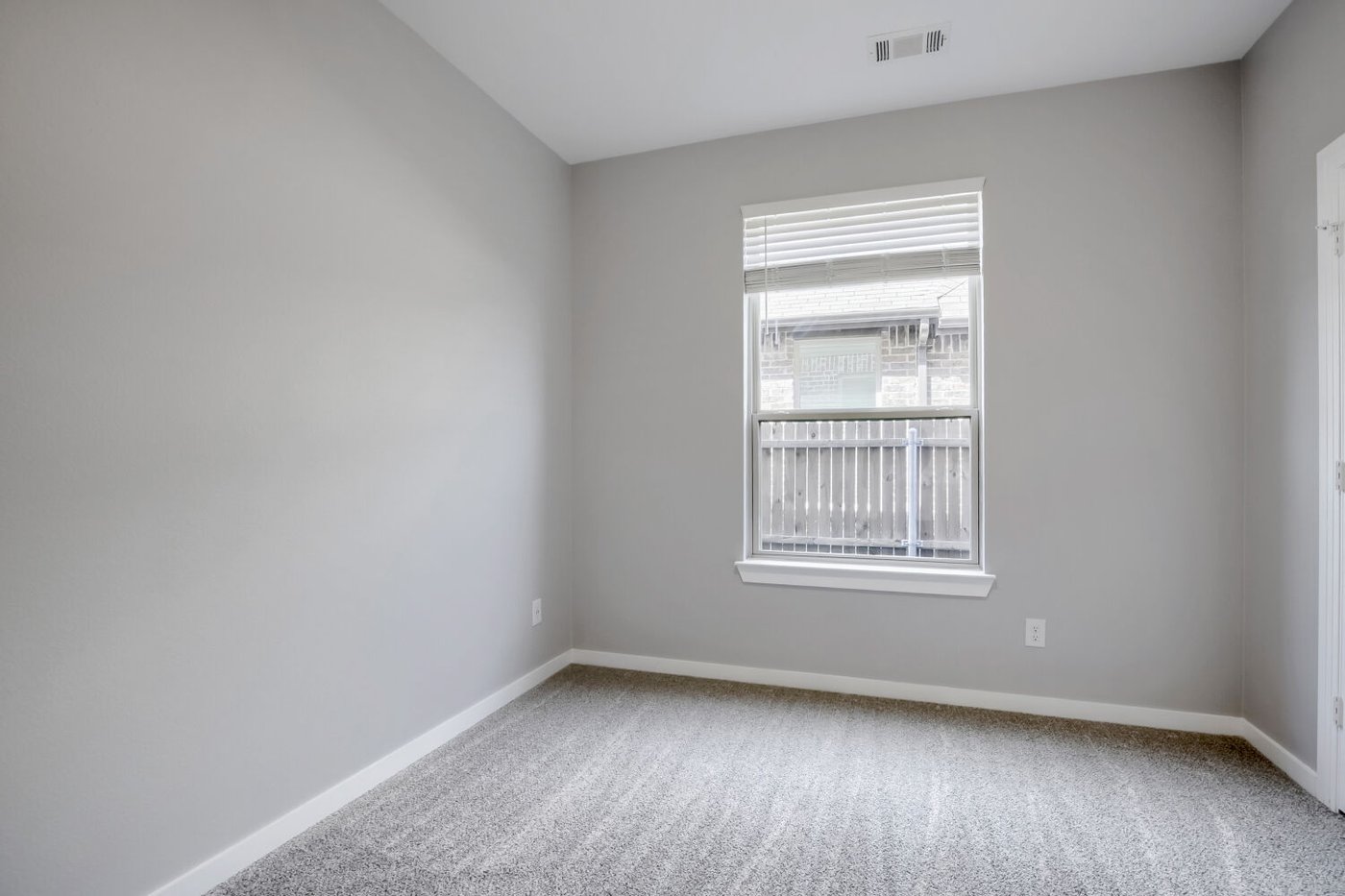 Second bedroom with new carpet and a window at 3925 Chesapeake Ln, Heartland