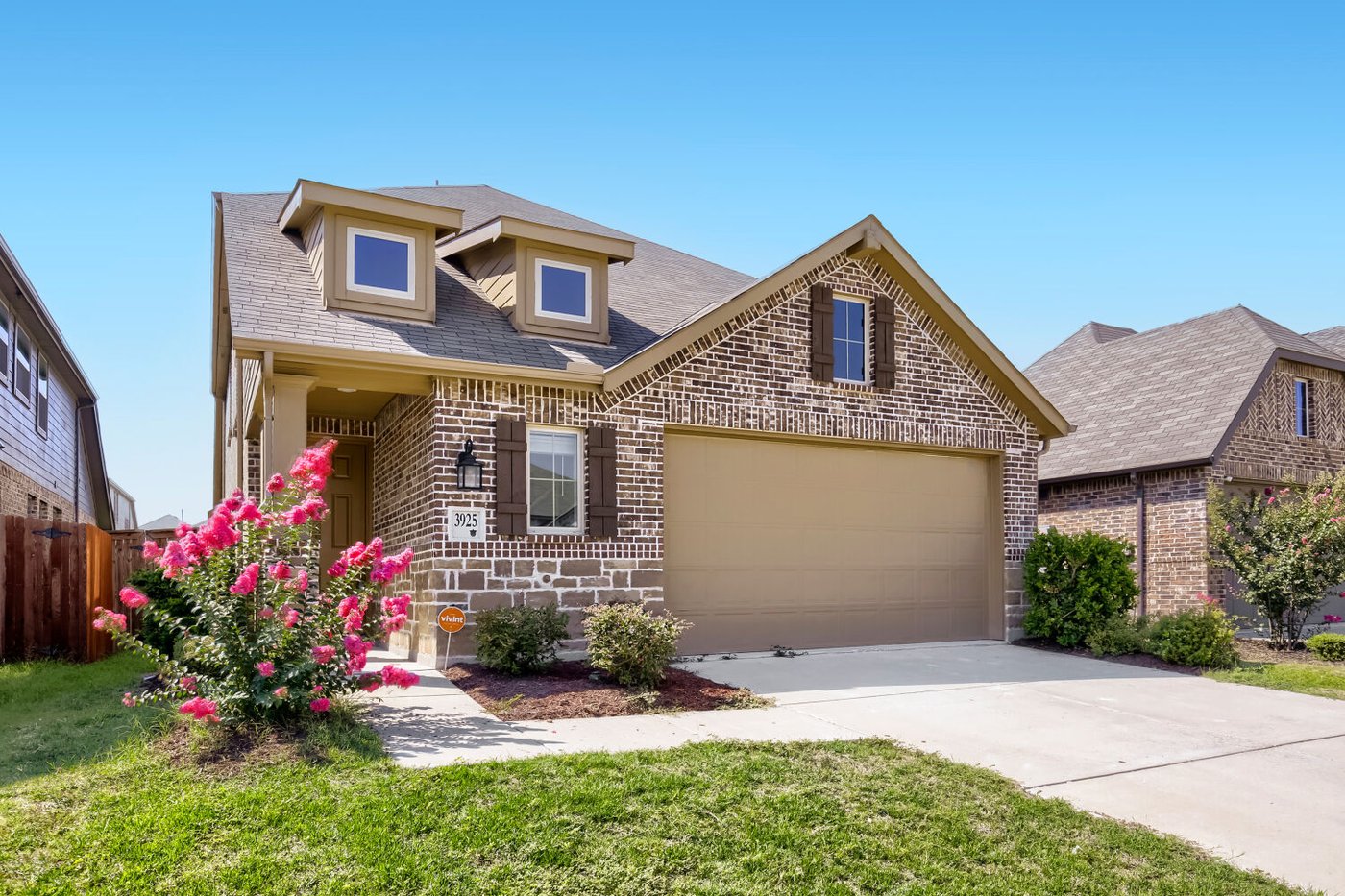 Curb view of 3925 Chesapeake Ln with landscaping and a two car garage in Heartland, TX
