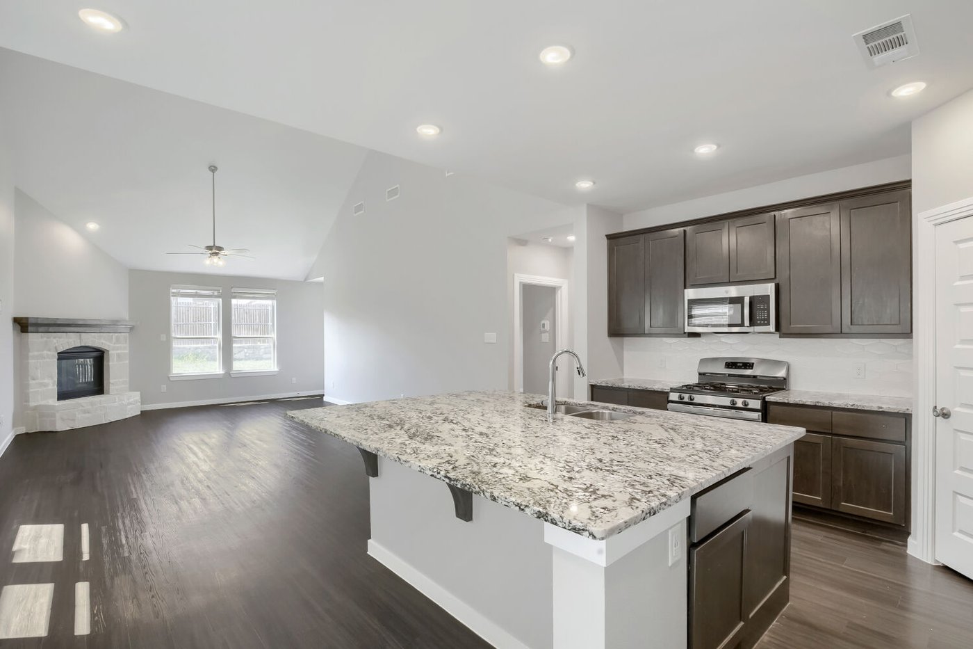 Modern kitchen with dark cabinetry, granite counters, and a center island at 3925 Chesapeake Ln