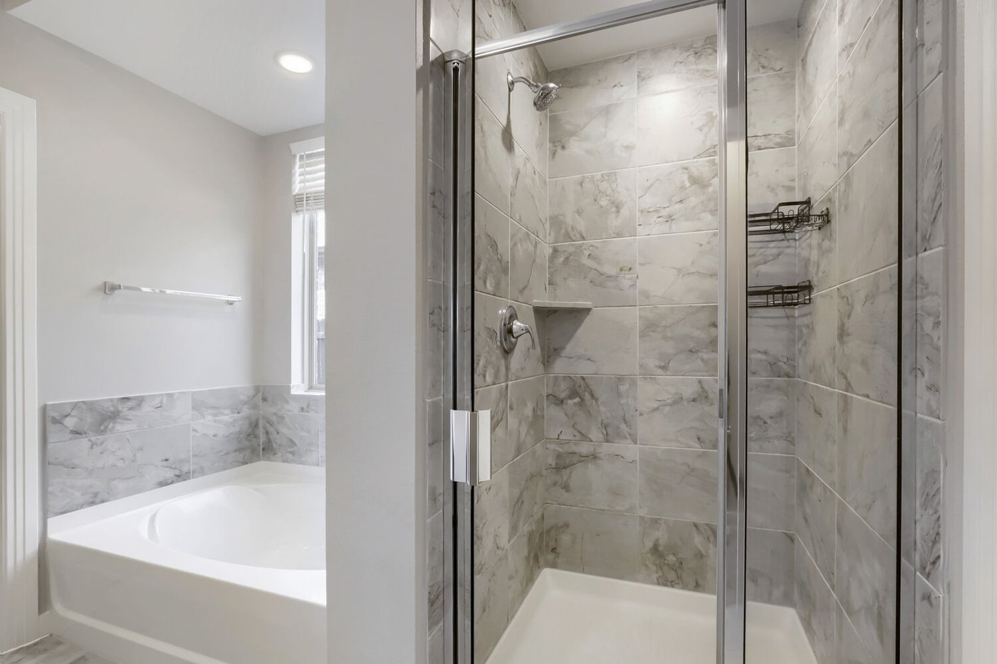 Primary bath with a separate tub and glass shower at 3925 Chesapeake Ln