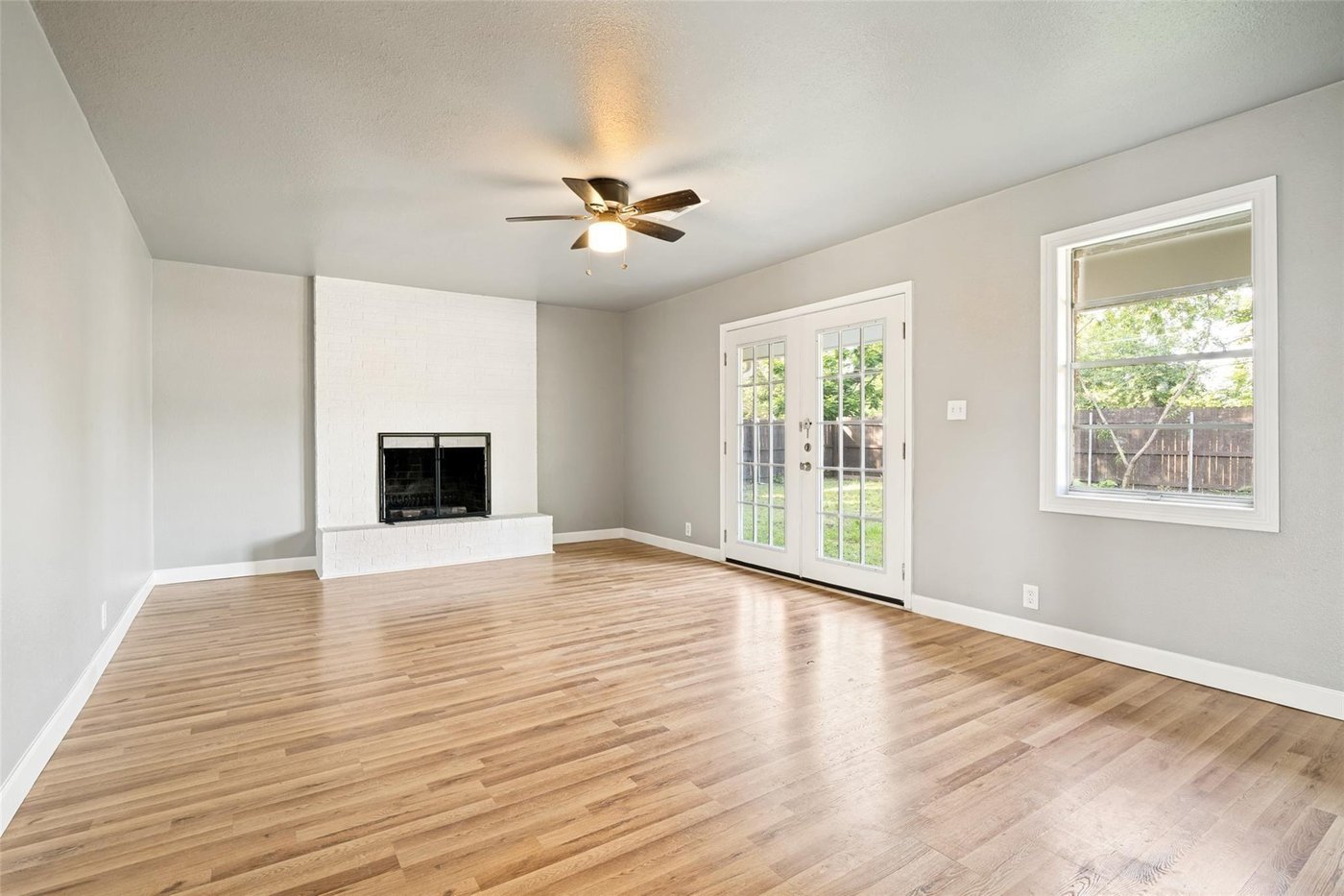 Living room with a fireplace and double doors to the backyard at 4401 Ivy Dr, Mesquite