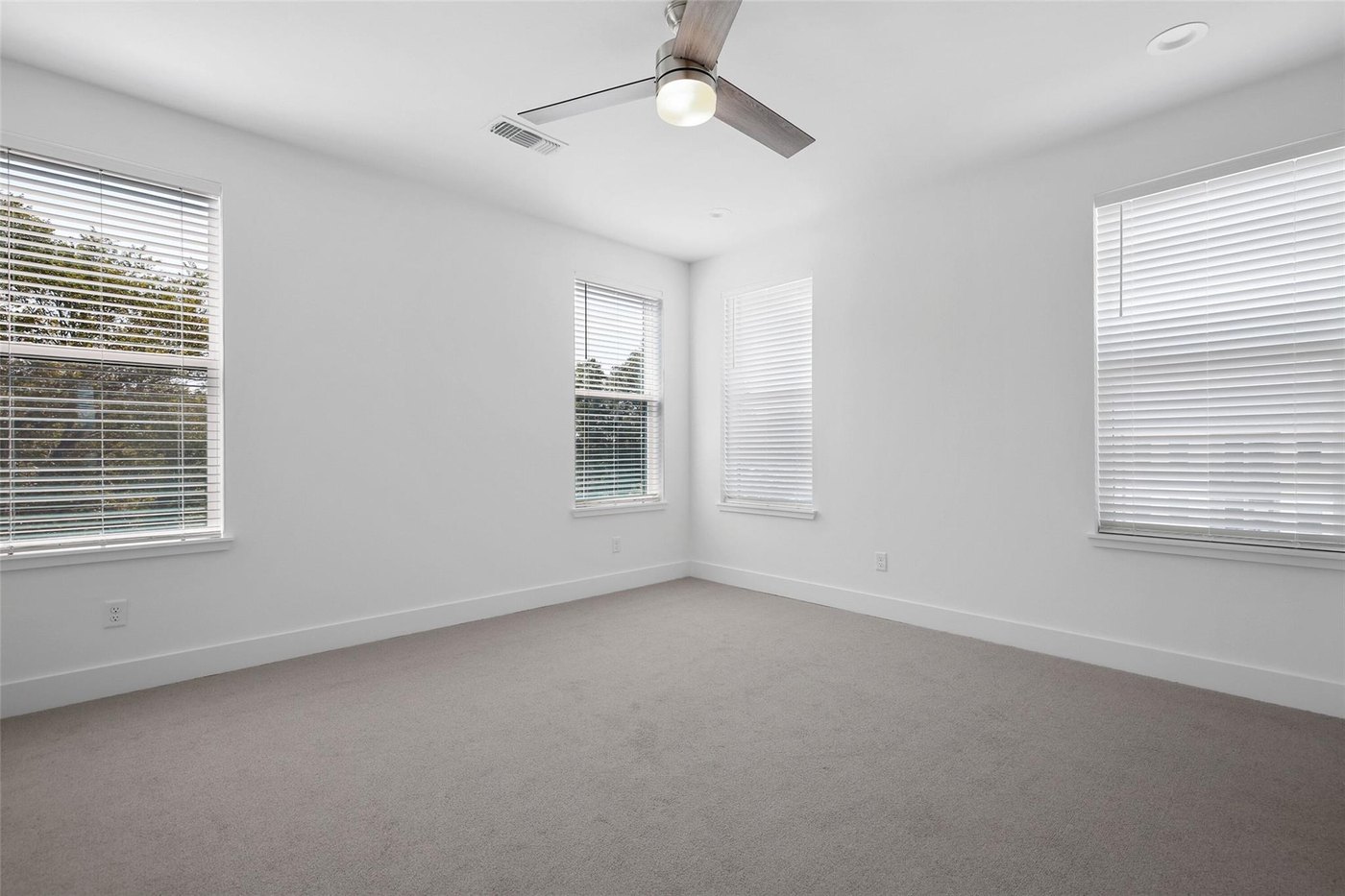 Carpeted bedroom with a ceiling fan and large windows at 4904 Lexington Ct, Dallas