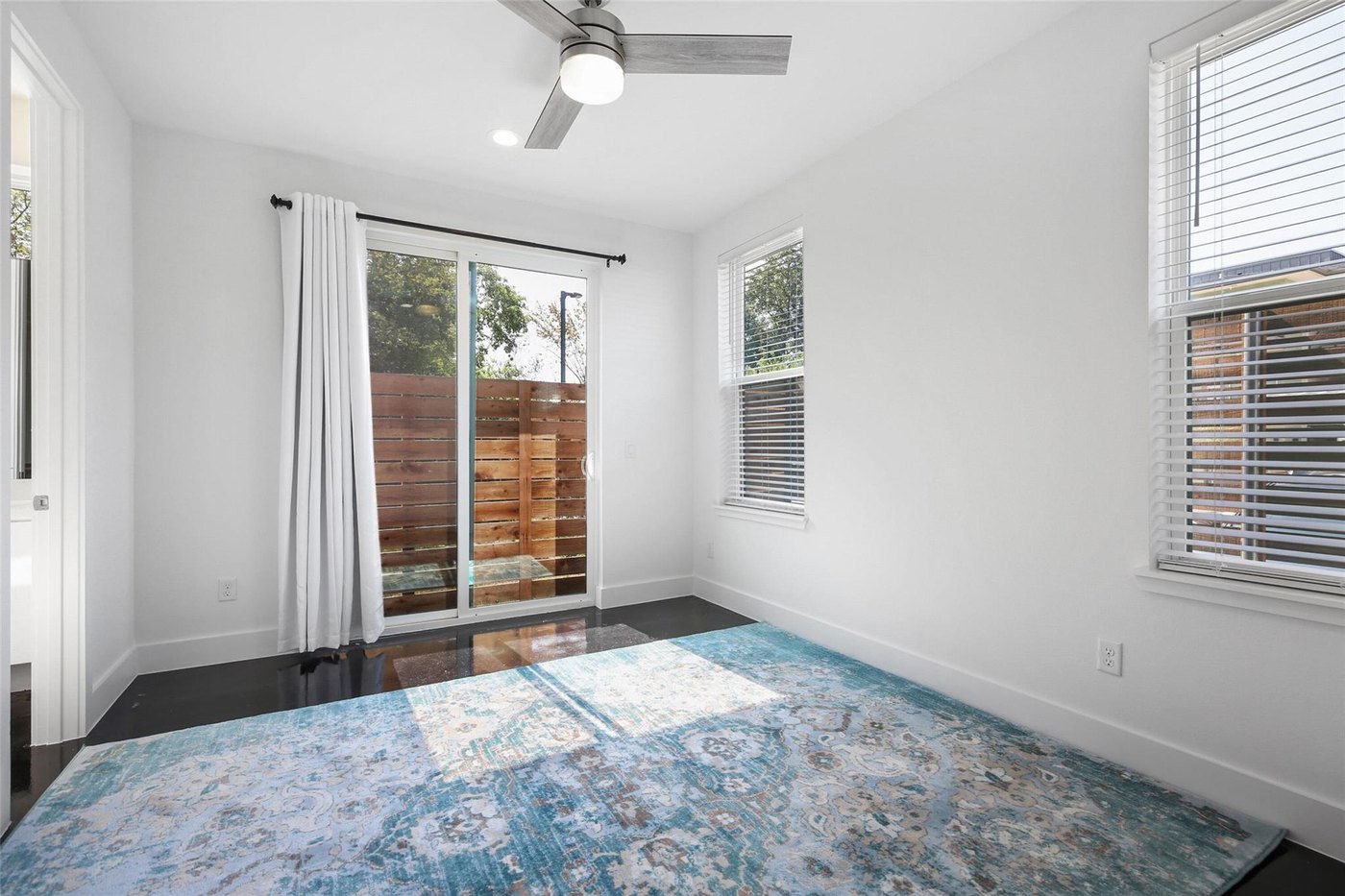 First floor bedroom with stained concrete and a private yard at 4904 Lexington Ct, Dallas