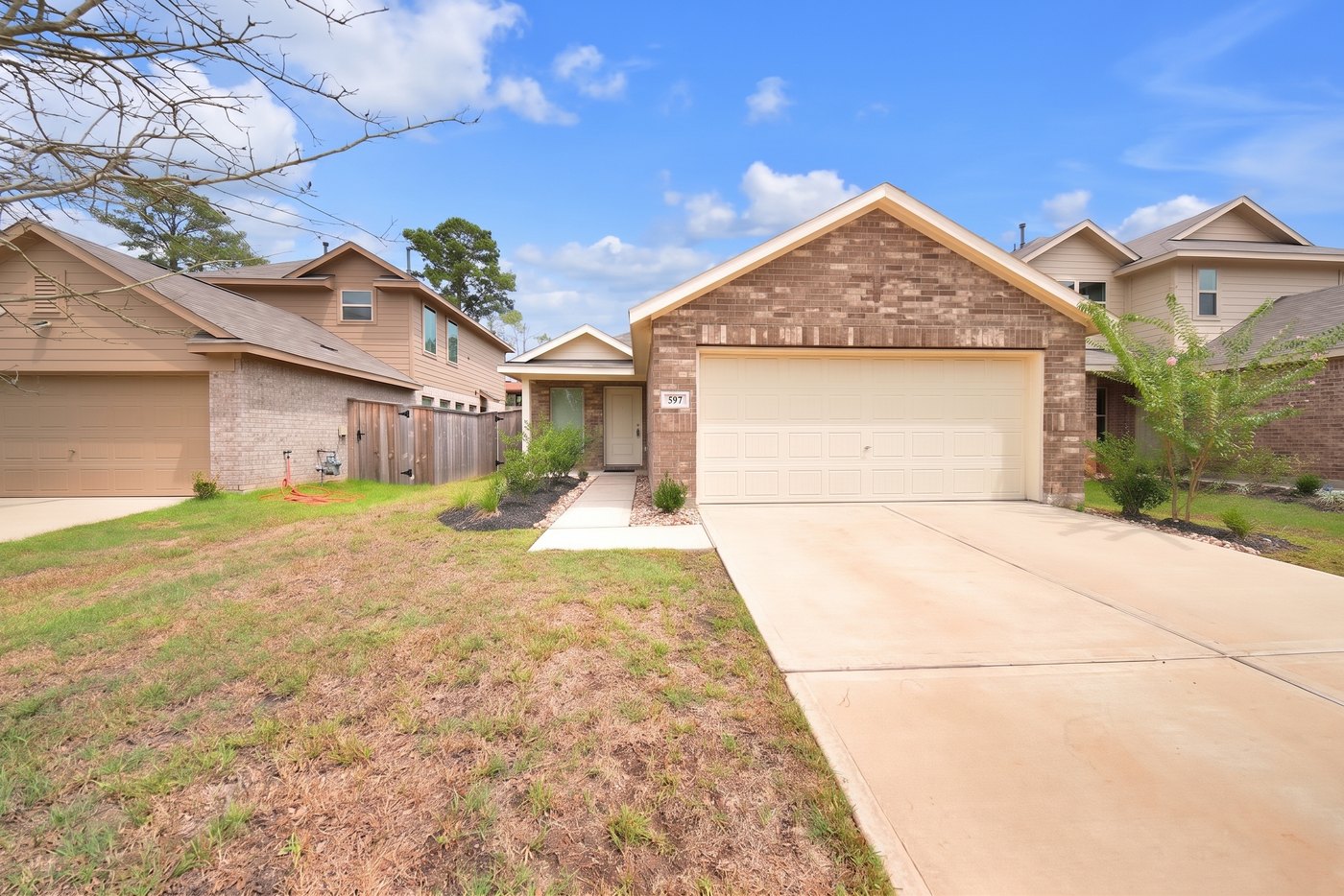 Front exterior of 597 Falling Cave Dr, a single story brick home for lease in Willis, TX