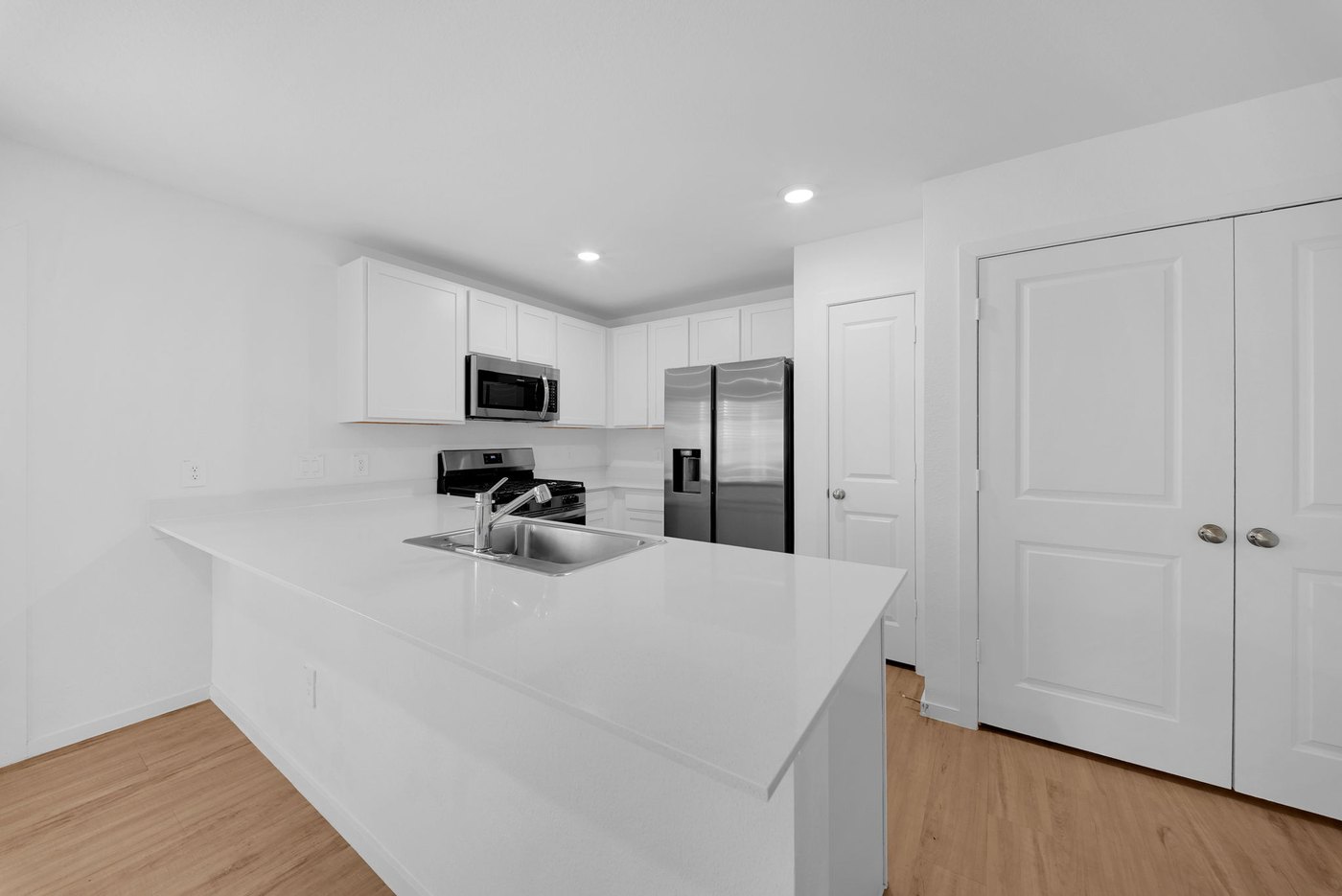 Island kitchen with modern appliances and white cabinetry at 597 Falling Cave Dr, Willis
