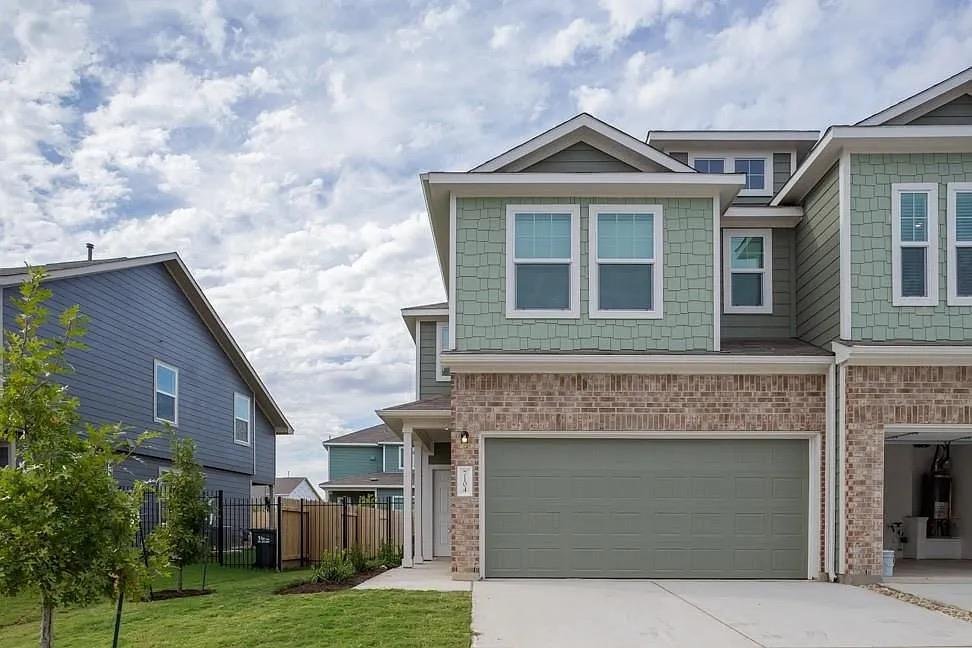Front exterior of 7104 Spotted Leaf Way, a two-story townhome with a garage for lease in Del Valle, TX