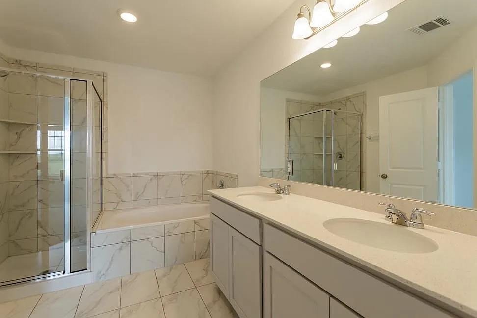 Primary bath with soaking tub and walk-in shower at 7104 Spotted Leaf Way, Del Valle
