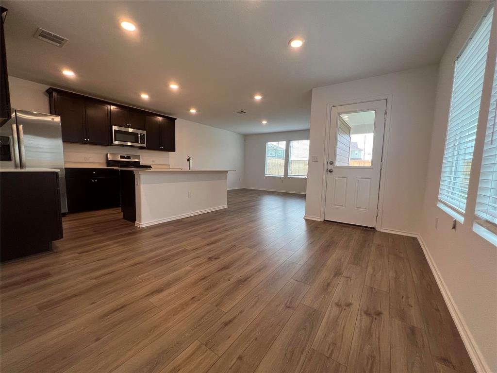 Open concept kitchen and living area at 7724 Spotted Leaf Way, Del Valle TX