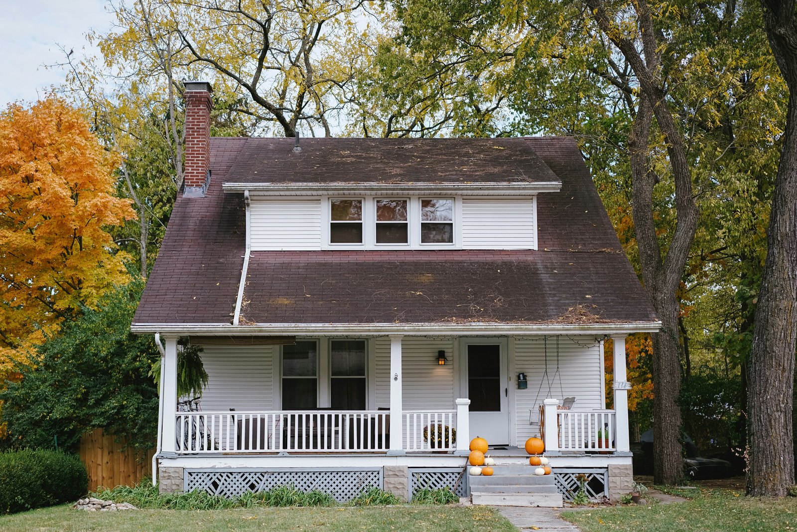 A suburban home with a For Sale sign and a red Foreclosure rider in the front yard